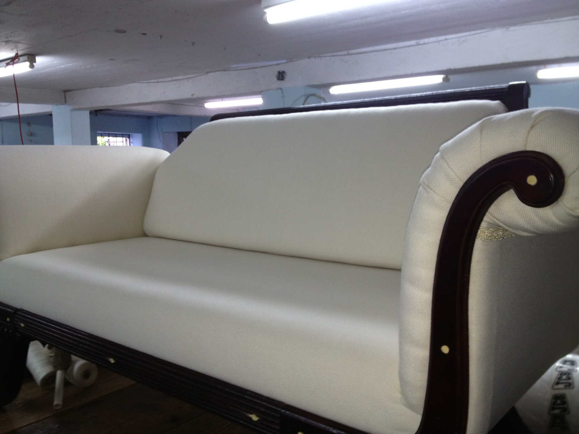 Scroll-arm antique sofa with carved mahogany frame newly upholstered in Barbados